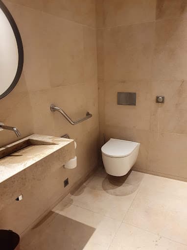 WC suspendu et barre d’appui dans une salle d’eau adaptée